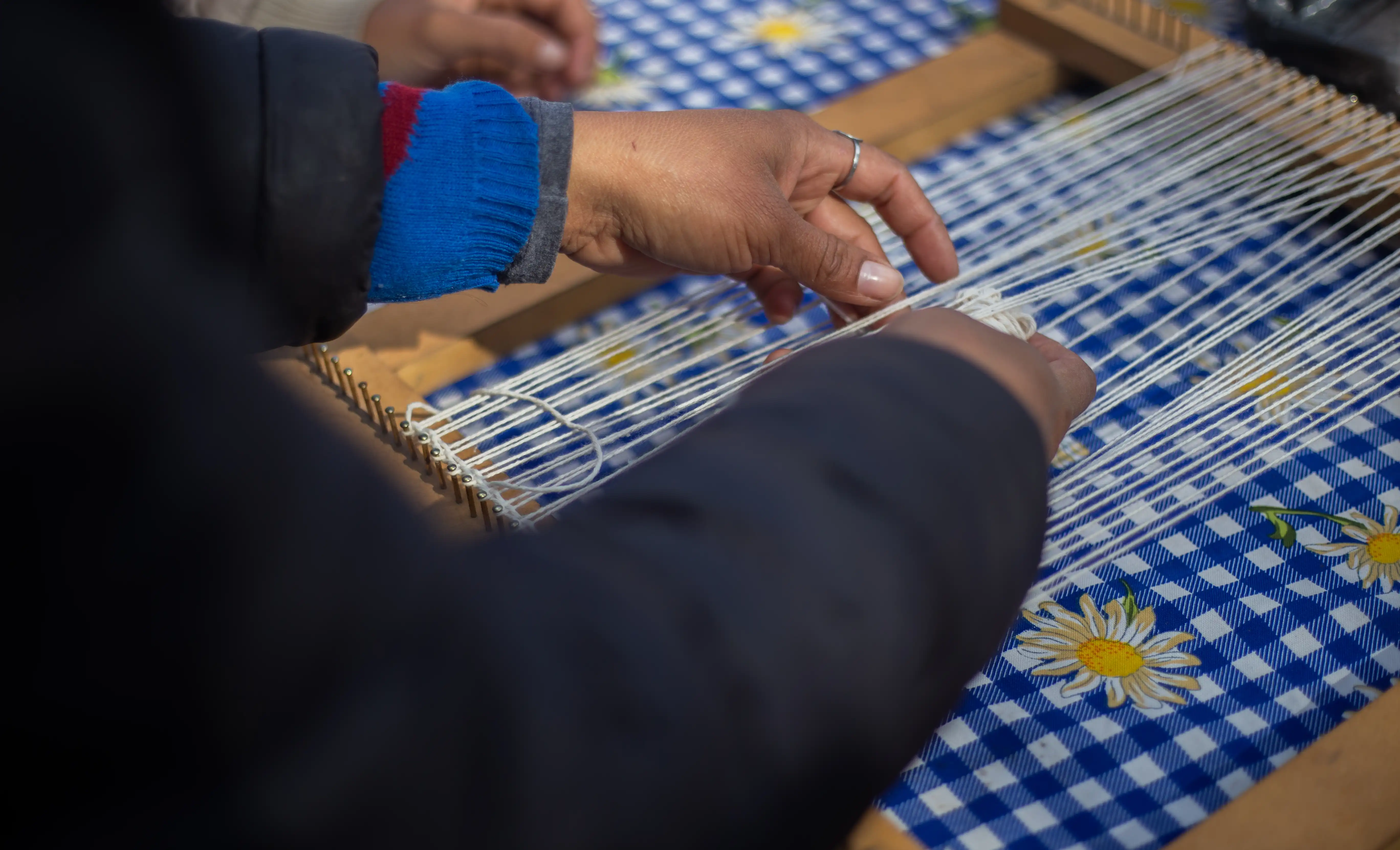 A person's hands weaving